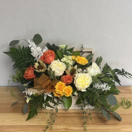 Mixed bouquet with orange, yellow, and white roses in a wooden box