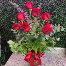 Red roses in a glass vase with a red ribbon
