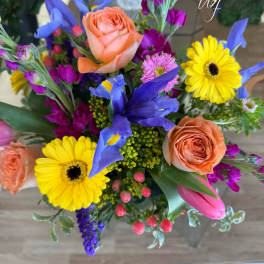 Colorful bouquet with peach roses, yellow gerbera daisies, and blue irises