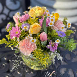 Mixed bouquet of pastel flowers in a clear glass vase