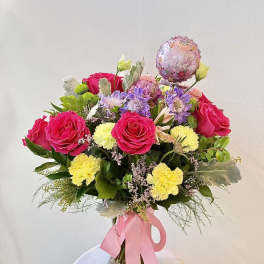 Pink rose bouquet with carnations and a birthday balloon in a glass vase