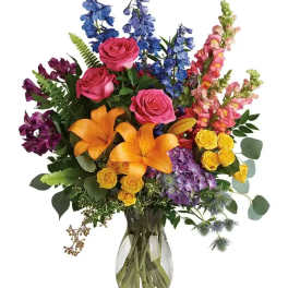 Colorful bouquet of roses, lilies, and snapdragons in a glass vase