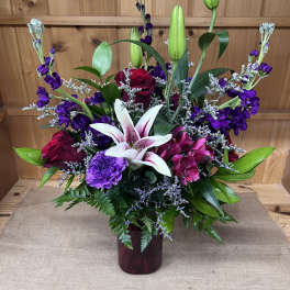Mixed bouquet with lilies, roses, and purple flowers in a vase