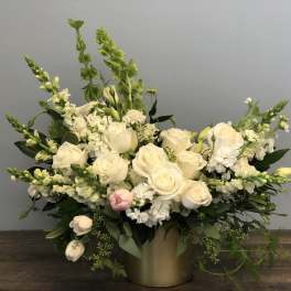 White rose arrangement with tall green spikes in a gold vase