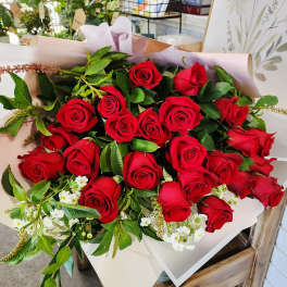 Bouquet of red roses wrapped in pale pink paper