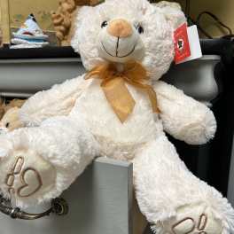 White teddy bear with a gold ribbon bow