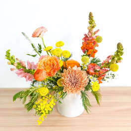 Colorful mixed flower arrangement in a white vase