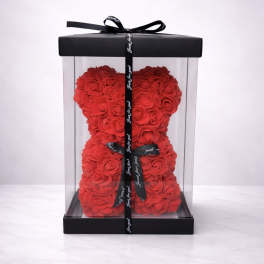 Red rose teddy bear in a clear gift box with a black ribbon