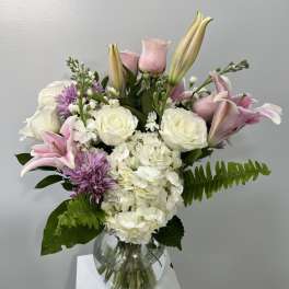 Pink lilies and white roses in a glass vase