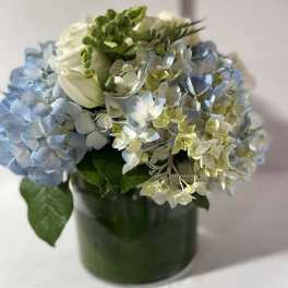 Blue and white hydrangea bouquet in a green vase
