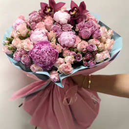 Pink and lavender bouquet with roses and orchids wrapped in paper