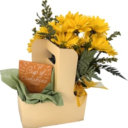 Yellow daisy bouquet in a gift bag with a tea box