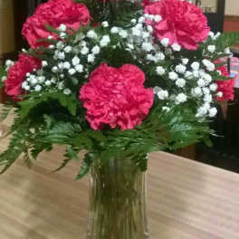 Pink carnations and white baby's breath in a clear glass vase