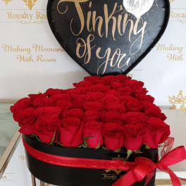 Heart-shaped box of red roses with a black "Thinking of You" sign