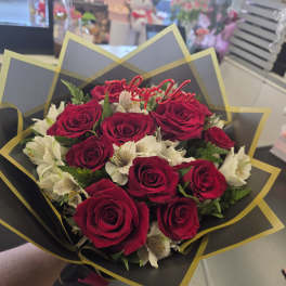 Bouquet of red roses and white flowers with a "Love You" topper