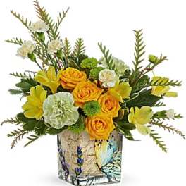 Yellow roses and carnations in a decorative glass vase