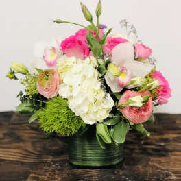 Pink and white floral arrangement in a green vase