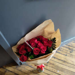 Bouquet of red roses wrapped in brown paper with a red ribbon