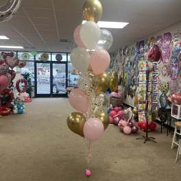 Cluster of pink, white, and gold balloons in a party store