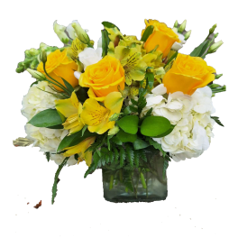 Yellow roses and white hydrangeas in a square glass vase