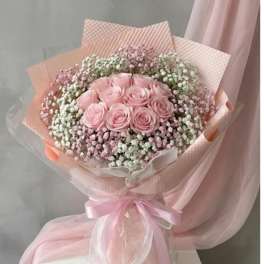 Pink rose bouquet wrapped in pastel paper with a ribbon