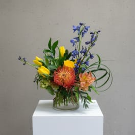 Colorful mixed flower arrangement in a clear glass vase