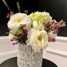 White flowers and pink filler in a textured silver vase