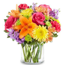 Mixed bouquet of roses, lilies, and daisies in a clear glass vase