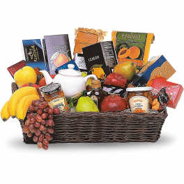 Gift basket with fruit, tea, cookies, and jam in a wicker tray