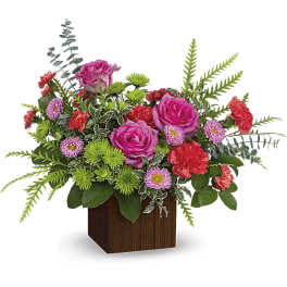 Pink roses and mixed flowers arranged in a wooden cube vase