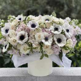 White and blush floral arrangement in a white vase