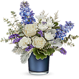 White roses and blue flowers arranged in a blue vase