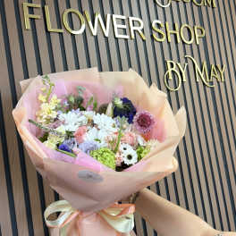 Pastel mixed flower bouquet wrapped in pink paper with ribbon