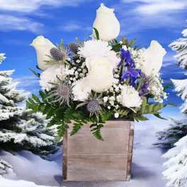 White roses and purple flowers in a wooden box