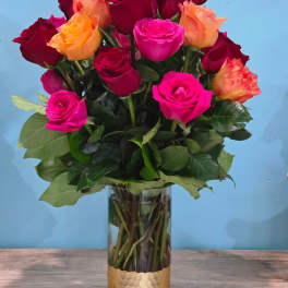 Mixed roses in a clear glass vase with a gold base