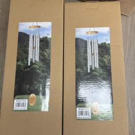 Two cardboard boxes with pictures of silver wind chimes on the front.