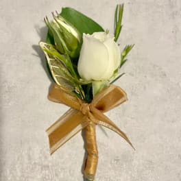 White rose boutonniere with gold ribbon bow on a light background