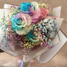 Bouquet of pastel rainbow roses with colorful baby's breath wrapped in white paper
