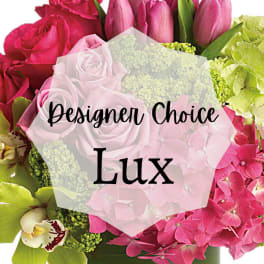 Lush pink and green flower arrangement with roses, tulips, orchids, and hydrangeas in a green vase
