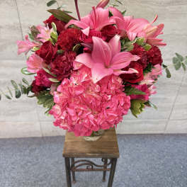 Pink and red floral arrangement in a clear glass vase