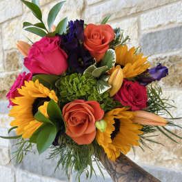 Hand-tied bouquet with roses, sunflowers, and lilies