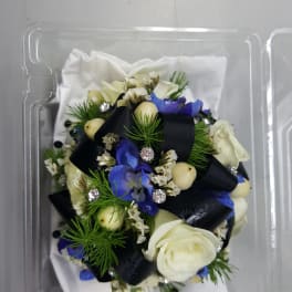 Small bouquet with white and blue flowers in a clear plastic box