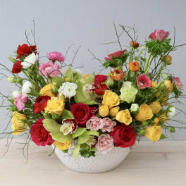 Mixed bouquet of roses and lisianthus in a white bowl vase