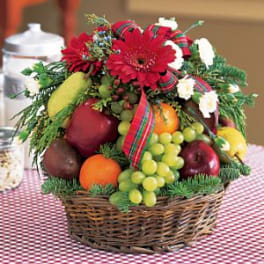 Fruit basket with red flowers and ribbon in a wicker basket