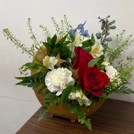 Red roses and white carnations in a gold vase with blue accents
