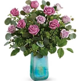 Pink and lavender roses in a blue glass vase