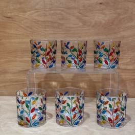 Six small glass votive holders with colorful leaf patterns
