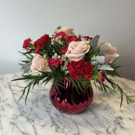 Pink roses and red carnations in a magenta glass vase