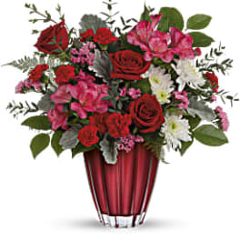 Red and pink mixed flower arrangement in a red vase