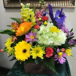 Colorful mixed flower arrangement in a wooden box